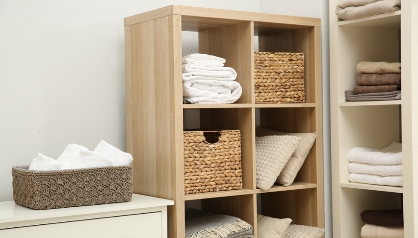 Home textile organization. Folded towels, blankets and pillows on shelving units indoors