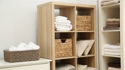 Home textile organization. Folded towels, blankets and pillows on shelving units indoors