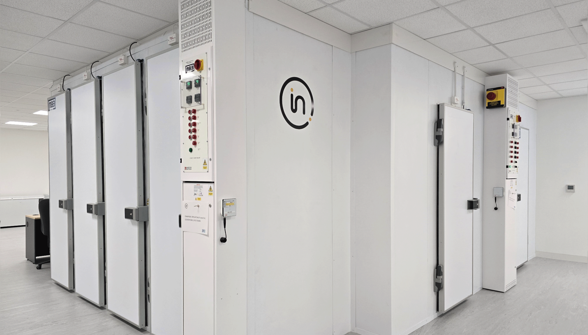 An expansive room characterized by white walls and doors, leading to stability cabinets, contributing to a light and uncluttered environment.