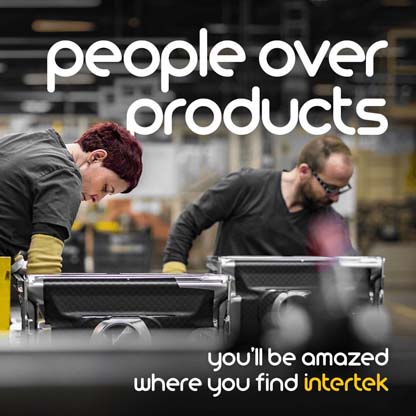 Workers wearing protective goggles on an assembly line