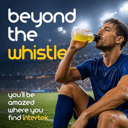 An athlete drinking an energy drink on a field in a sports stadium
