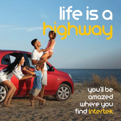 A family enjoying the beach next to their parked car